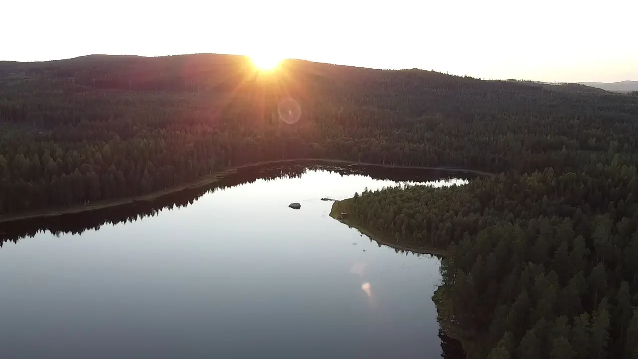 Skogssjö i solnedgång sedd från ovan